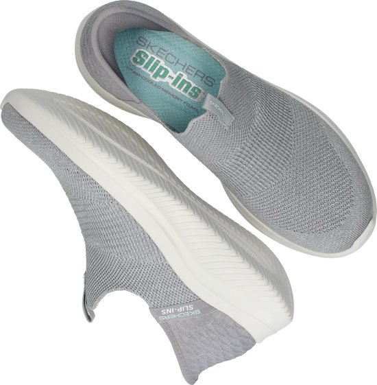 Paar grijze Skechers Slip-ins instappers. Eén sneaker toont de zool, de ander de binnenkant.