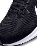 Detail van een zwarte Nike hardloopschoen, met veters en mesh materiaal.