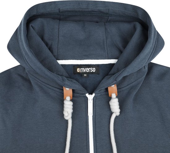Sluiting en capuchon van een donkerblauwe hoodie met witte rits en veter.
