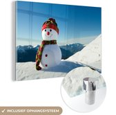 MuchoWow® Glasschilderij 60x40 cm - Schilderij acrylglas - Een kerstpop in het besneeuwde landschap tijdens de winter - Foto op glas - Schilderijen
