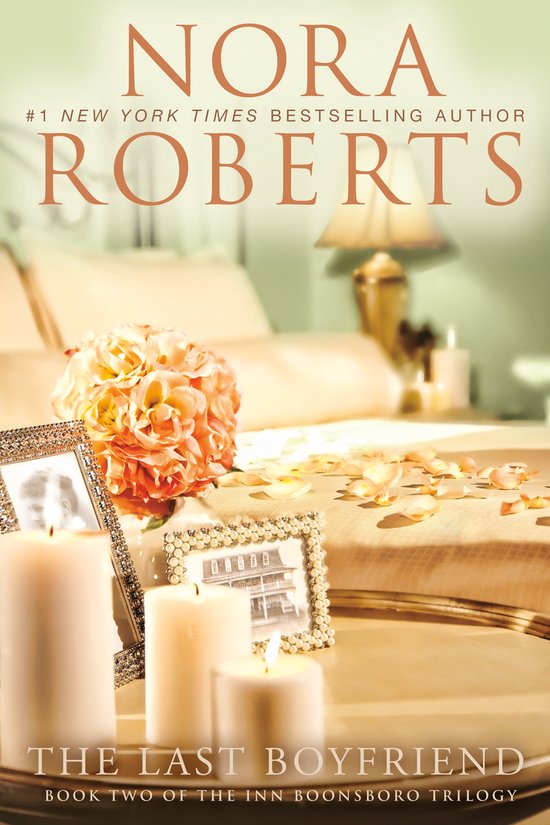 Boekomslag van 'The Last Boyfriend', deel twee van de Inn Boonsboro trilogie, door Nora Roberts. Met een bed in de achtergrond en decoratie van kaarsen en bloemen.