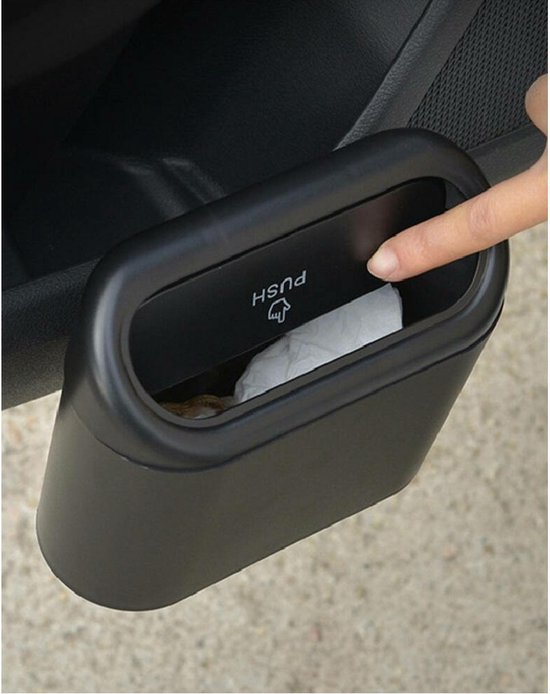 Vinger drukt op het deksel van een zwart bakje, geplaatst in een auto-deurpaneel.