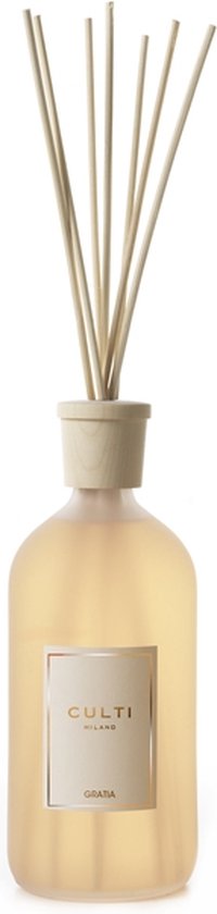 Culti Milano Gratia geurstokjes in een glazen fles met een lichtgele vloeistof en houten stokjes.