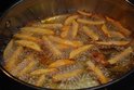 Frietjes bakken in een pan met bruisende hete olie.