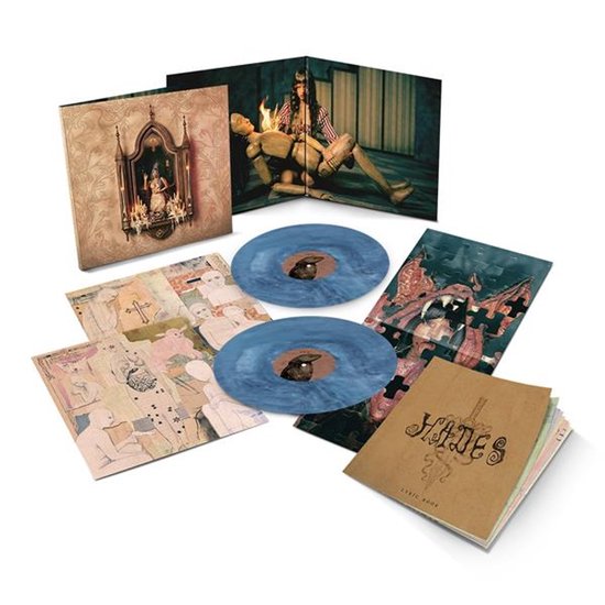 Een opengeklapte hoes met twee blauw-gemarmerde vinylplaten. Bevat artwork van een vrouw met een pop.