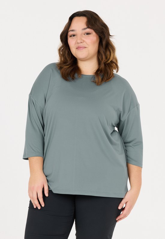 Model in blauwgrijze T-shirt met driekwart mouwen.