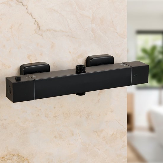 Mitigeur de douche thermostatique noir mat sur un mur de carrelage en marbre.