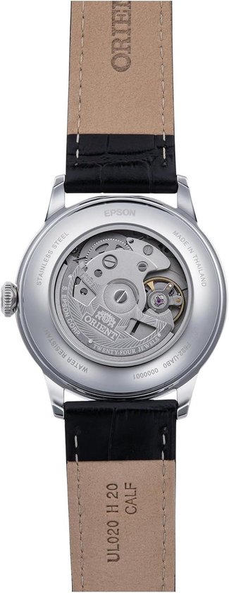Onderkant Oriënt horloge met zichtbaar automatisch uurwerk, roestvrij staal en bruine band.