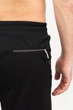 Detail van de ritszak van een zwarte korte sportbroek voor heren.