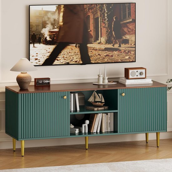 Groen tv-meubel met walnootkleurig blad en gouden poten, met boeken en decoratie.