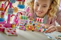 Kinderen bouwen samen aan het LEGO Friends Candy & Cupcake Reuzenrad met kermisattracties.