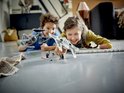 Twee kinderen spelen op de vloer met de LEGO Star Wars Mandalorian Fang Fighter en TIE Interceptor.