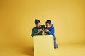 Femme et enfant construisent un lapin LEGO sur une table.
