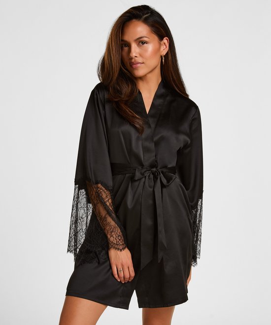 Model met lang bruin haar draagt een zwarte satijnen kimono met ceintuur