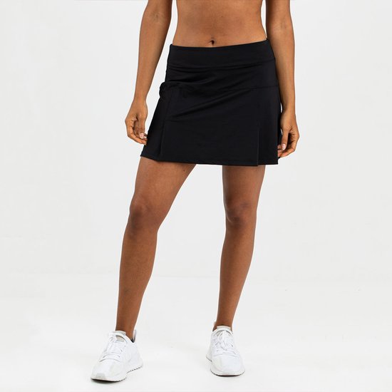 Zwarte sportrok met een elastische tailleband en zijsplitten, gedragen door een model op sportschoenen.