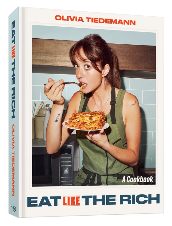 Boek met de titel 'EAT LIKE THE RICH' met een vrouw in een keukenschort die lasagne eet.