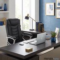 Zwarte bureaustoel in een stijlvol kantoor met een laptop, toetsenbord en muis op een bureau.