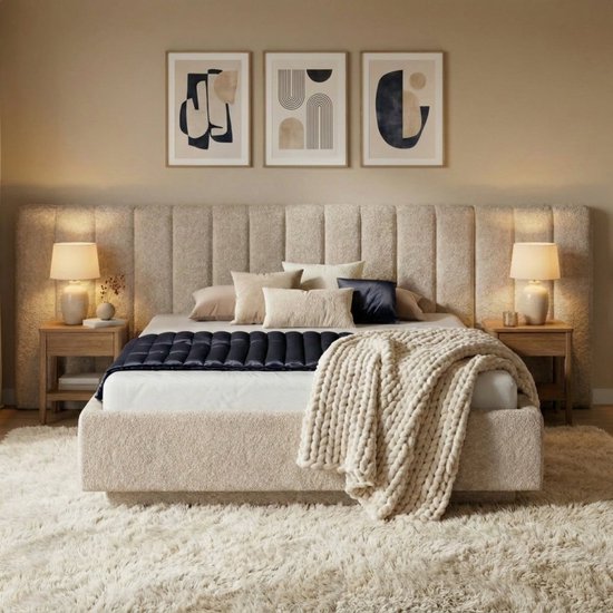 Lit luxueux avec tête de lit et cadre texturés beiges, agrémenté de coussins, d'une couette bleu foncé et d'un jeté en tricot.
