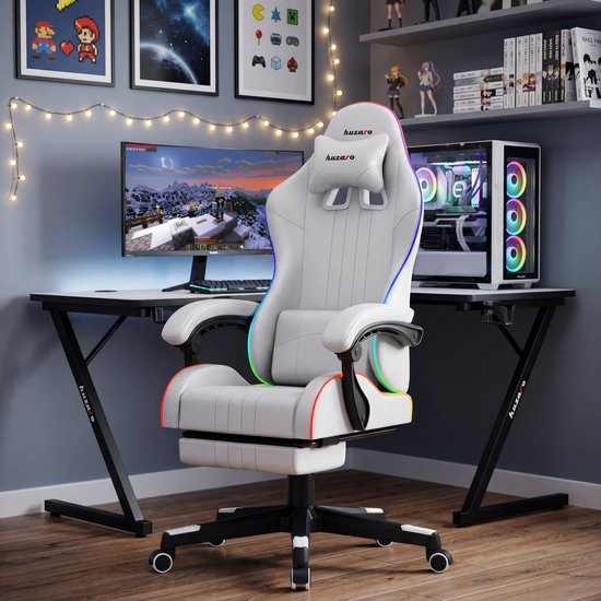 Witte Huzaro Force 4.7 gamestoel met RGB LED-verlichting, in een gamingopstelling met bureau, computer en monitor.