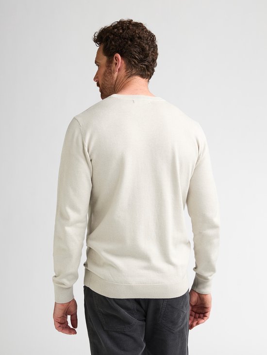 Man met beige trui met lange mouwen, rug en achterkant hoofd zichtbaar.