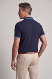 Achterkant van een marineblauwe poloshirt met geborduurd logo en blauw-witte strepen op kraag en mouwen.