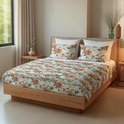 Een tweepersoonsbed met lichtgroen bloemenprint dekbed en bijpassende kussens. De houten ombouw van het bed is zichtbaar.