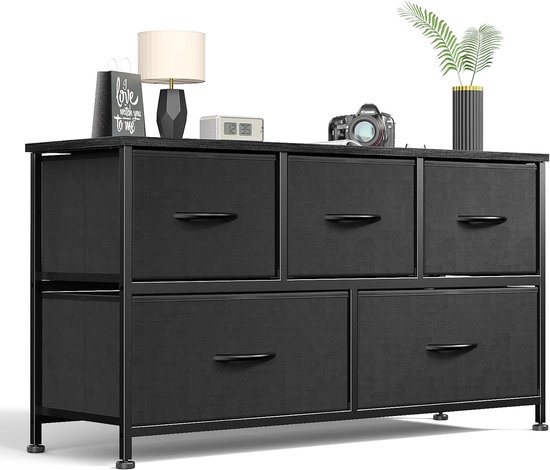 Zwarte 6-ladencommode met een metalen frame en zwarte handgrepen. Bovenop staan decoraties.