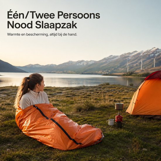 Vrouw in een oranje noodslaapzak bij een tent aan een meer met bergen op de achtergrond.
