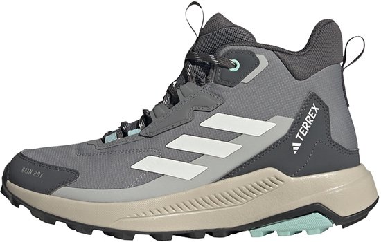 Grijze mid-hoge wandelschoen voor dames met witte Adidas strepen, beige zool en lichtblauwe accenten. Met 'TERREX' en 'RAIN.RDY' opdruk.