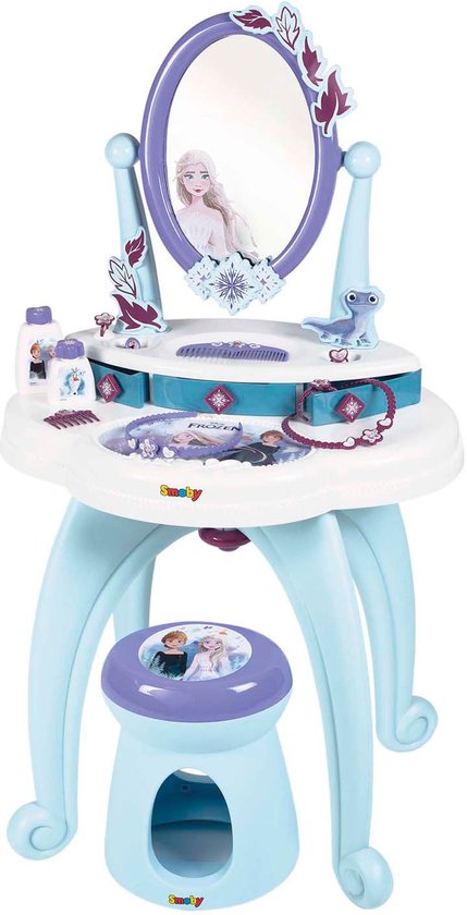Een witte speelgoedkaptafel met blauwe pootjes, spiegel met Frozen-afbeelding, kam, flesjes en sieraden. Een bijpassend krukje staat ervoor.