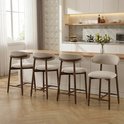 Vier beige barkrukken met houten poten en rugleuning in een keukenopstelling.
