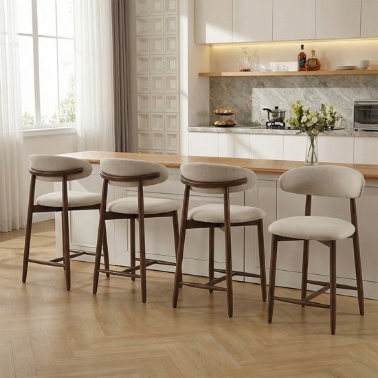 Vier beige barkrukken met houten poten en rugleuning in een keukenopstelling.