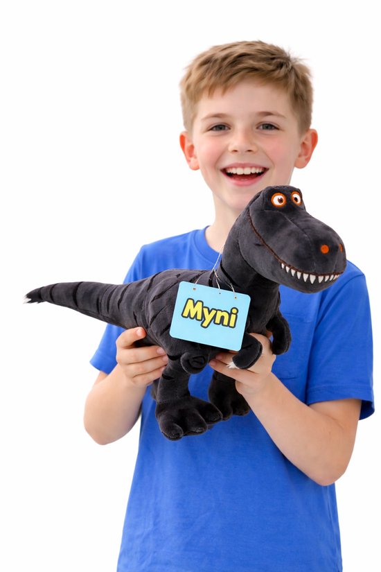 Een jongen met een blauw shirt houdt een zwarte pluche dinosaurus met grote ogen vast. De dinosaurus heeft een label met 'Myni'.