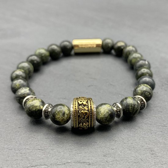 Armband van groene slangenhuidkralen met
een opengewerkte gouden cilinder en zilveren
accenten.
