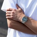 Zilverkleurig Casio horloge met groen display gedragen om de pols van een man.