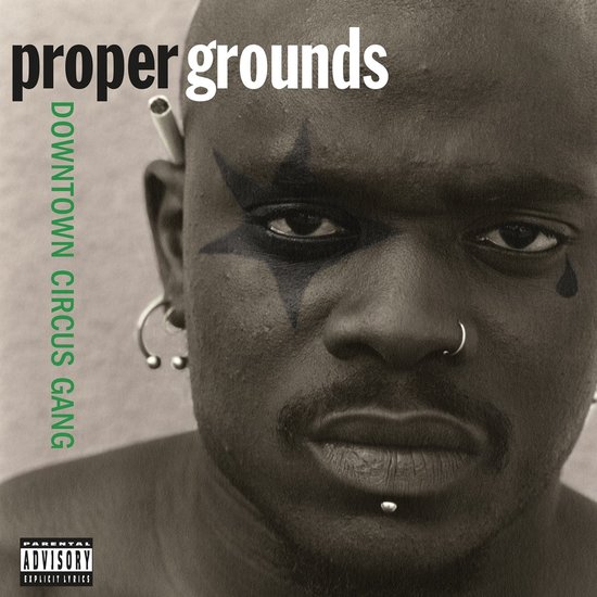 Albumhoes met close-up van een man met gezichtsmake-up en piercings. Tekst: 'proper grounds DOWNTOWN CIRCUS GANG'.