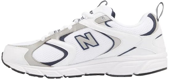 Zijaanzicht van de witte New Balance sneaker met zilverkleurige en marineblauwe accenten.
