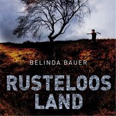 Boekomslag 'Rusteloos Land' met een silhouet van een man op een heuvel onder een kale boom.
