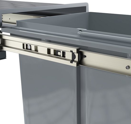 Detailopname van de metalen ladegeleiders en de grijze vuilnisbakken van de uittrekbare afvalbak.