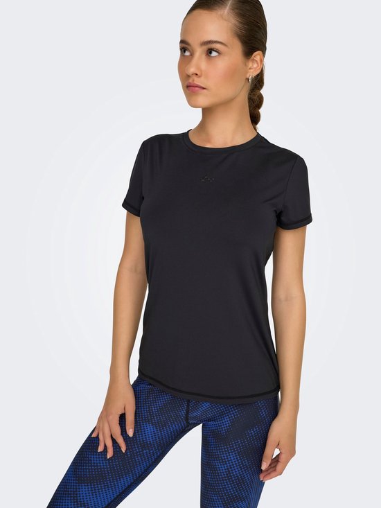 Model draagt zwart t-shirt met korte mouwen en ronde hals, gecombineerd met een blauw-zwarte legging.