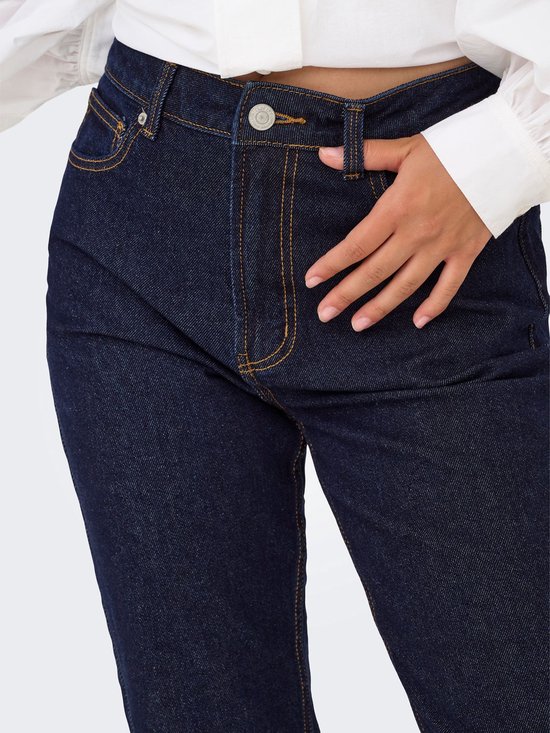 Sluiting van een donkerblauwe jeans met een hoge taille, met gele stiksels.