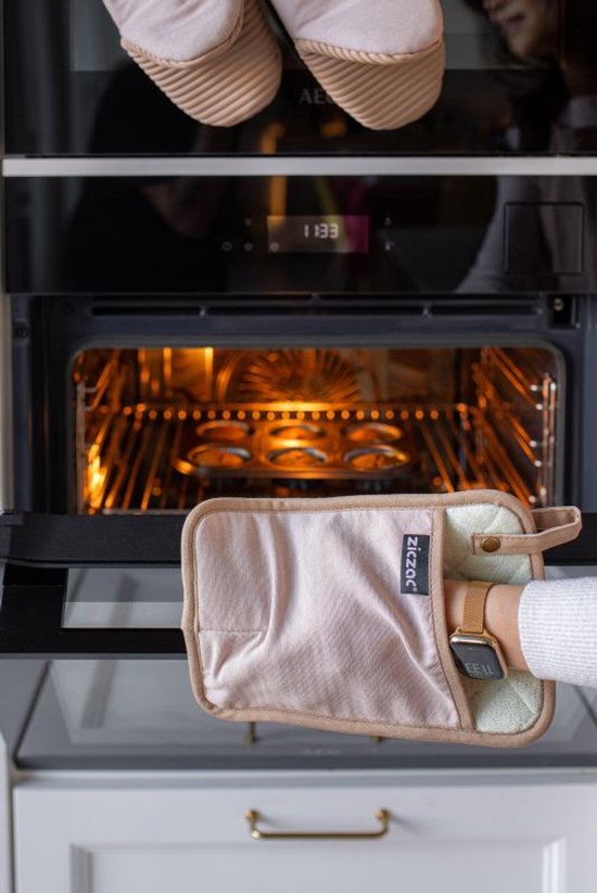Beige pannenlap met beige band wordt uit een oven gehaald.