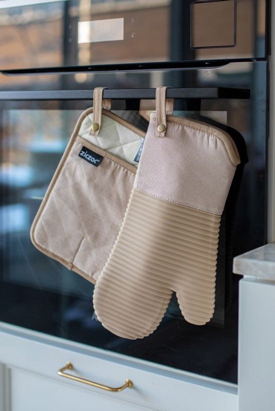 Beige ovenwant en pannenlap hangen aan een oven.