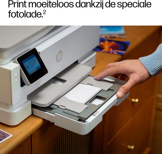 Close-up van een hand die een speciale fotolade uit een witte HP printer trekt.