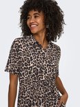 Close-up van een model in een midi-jurk met luipaardprint en korte mouwen.