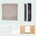 Gevouwen beige partytent, frame, draagtas, touwen, haringen, handleiding en doos.