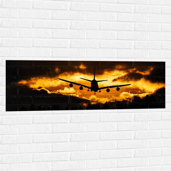 Muursticker - Silhouet van Passagiersvliegtuig boven de Bomen tijdens Zonsondergang - 120x40 cm Foto op Muursticker
