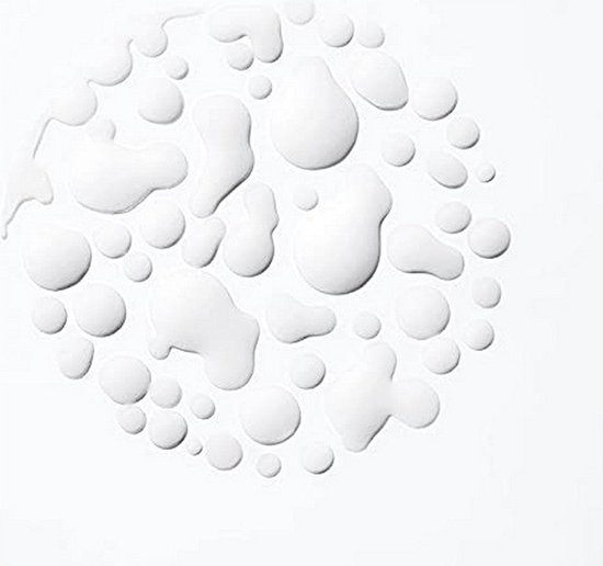 Plusieurs gouttes de lotion blanche dispersées sur fond blanc.