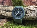Groen G-Shock horloge met zwarte wijzerplaat op mos.
