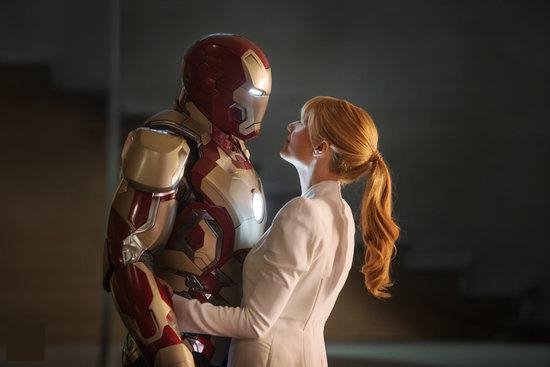 Iron Man in rood en wit pantser kijkt naar Pepper Potts in een wit shirt, die naar hem opkijkt.